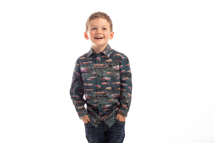 Smiling boy wears the Pladra Toddler Cubs Printed Shirt-Trout and jeans, hands in pockets, against a white background.