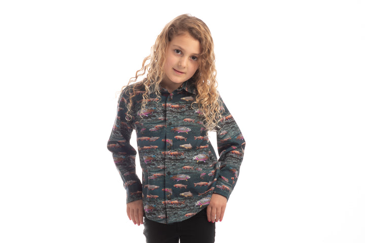 Toddler with long curly hair wears a Pladra Toddler Cubs Printed Shirt - Trout, standing against a white background.