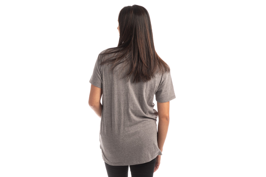 A woman with straight dark hair faces away from the camera, wearing a Women&