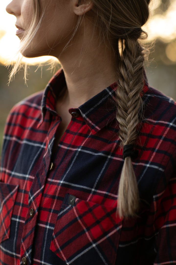 A woman with a fishtail braid over one shoulder wears the Women&
