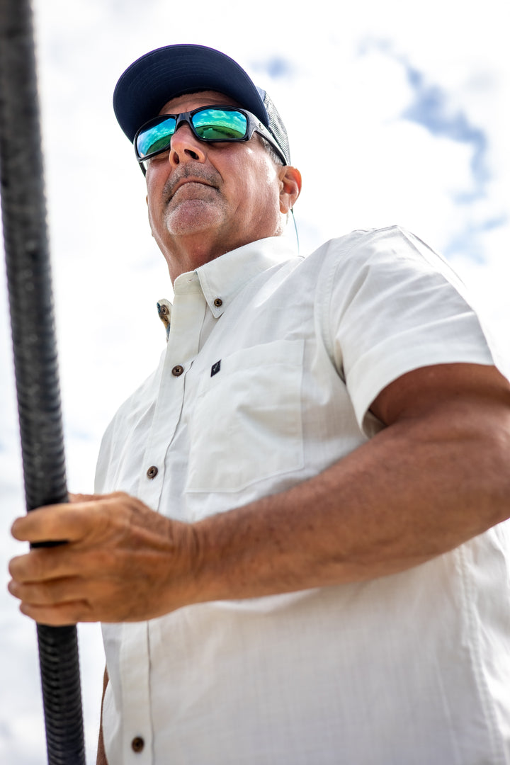 A man in sunglasses, a cap, and the Men&